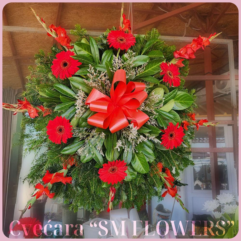 Pogrebni venac od crvenih gerbera i crvenih gladiola sa velikom crvenom mašnom